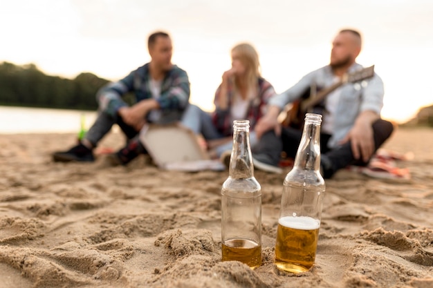 Photo long shot unfocused group of people with two bottles of beer