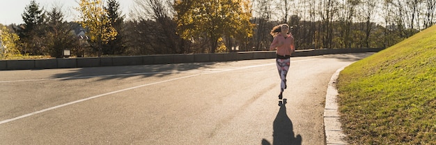 Photo long shot woman jogging in the park