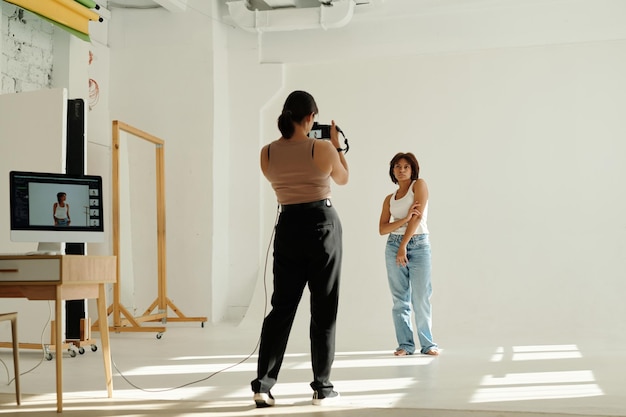 Long shot of young african american woman posing for camera in studio