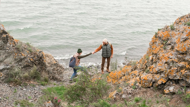 Photo long shot young couple walking down towards sea