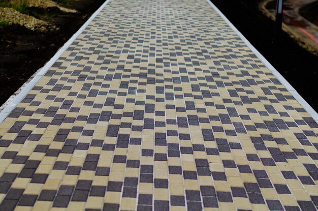 A long sidewalk made of colored tiles.