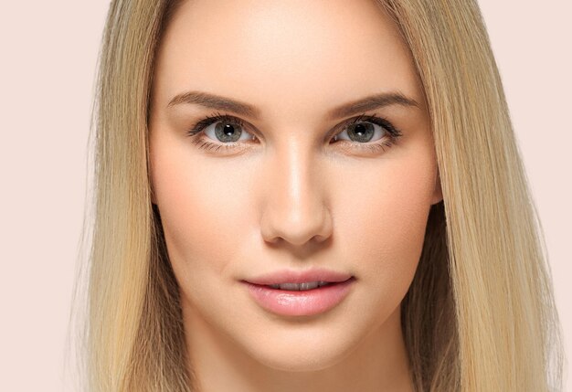 Photo long smooth hair beauty woman close up portrait blonde hairstyle. color background pink