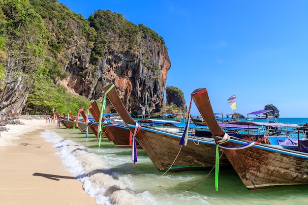 프라낭 비치 크라비 태국(Phra Nang Beach Krabi Thailand)의 롱테일 보트와 석회암 절벽과 산이 있는 청록색 수정처럼 맑은 바닷물
