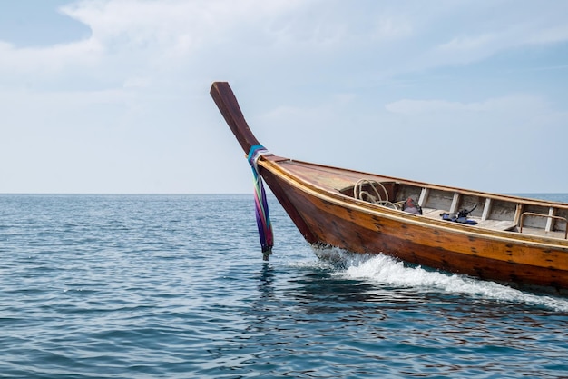 Long tail wooden boat sail on blue sea