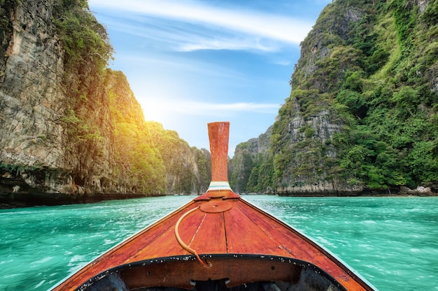 Long-tail wooden boat sailing on Pileh lagoon limestone mountain at Krabi, Thailand