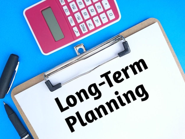 Long term planning text on paper with pen and calculator