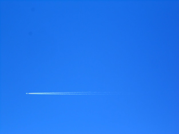 A long trail of jet plane on blue sky