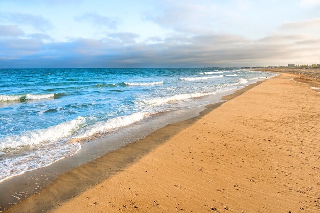 Long tropical sandy beach with surf and sea waves