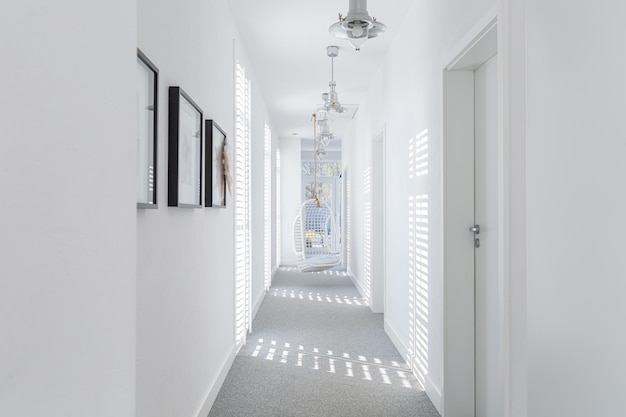 Long white corridor with modern lightning and armchair