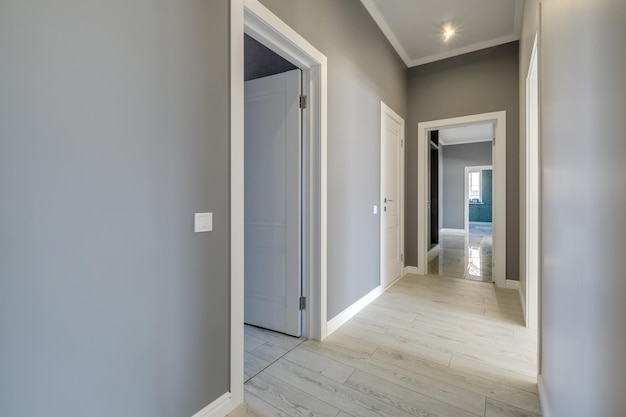 Длинный белый пустой коридор в интерьере вестибюля современных квартир, офиса или клиники