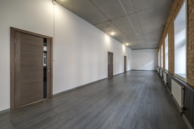 Long white empty corridor in interior of entrance hall of modern apartments office or clinic