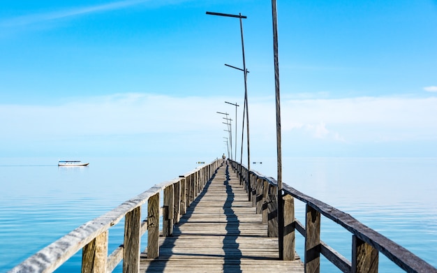 Photo a long wooden pier on clear turquoise water