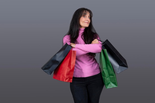 Longhaired brunette woman with gift bags and funny expression