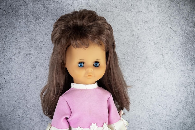Photo longhaired doll in pink blouse on gray background