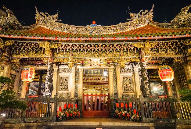 Longshan 사원, 타이페이, 대만. 금빛으로 빛나고 밤에는 매우 아름답습니다.; 사진의 글은 영어로 용산사를 의미 함)