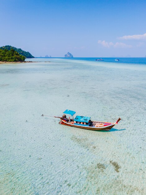 longtail boat in the turqouse colored ocean with clear water at Koh Kradan Thailand