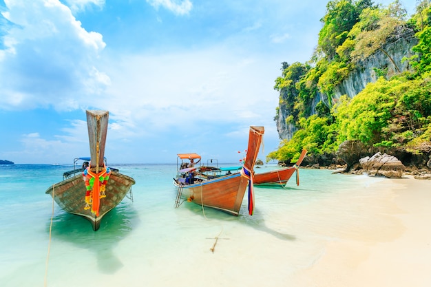 Foto longtale boot op het strand in phuket, thailand. phuket is een populaire bestemming die beroemd is om zijn stranden.
