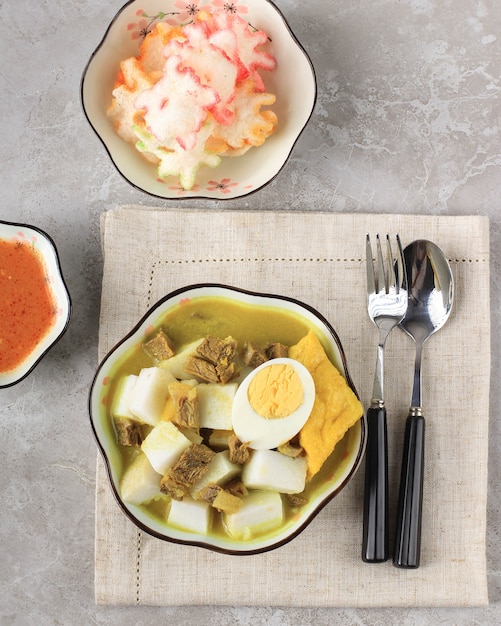 Lontong kari sapi o curry di manzo indonesiano con torta di riso. cibo di strada popolare per la colazione a west java, indonesia