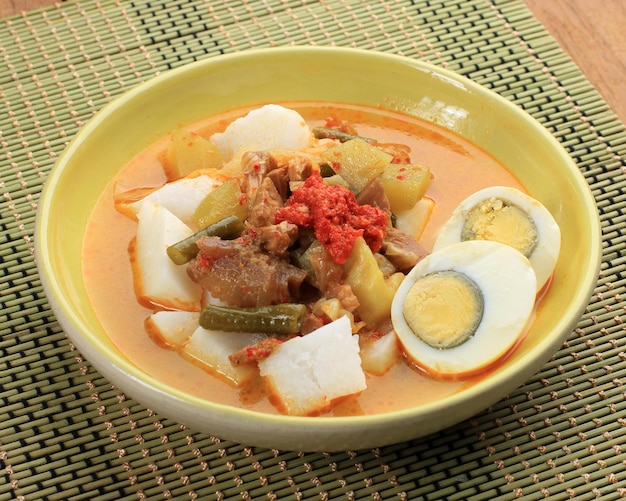 Lontong Sayur Indonesische keuken Gecomprimeerde rijstwafel of lontong met groenten chayote en kousenband gekookt in kokosmelk en kruiden
