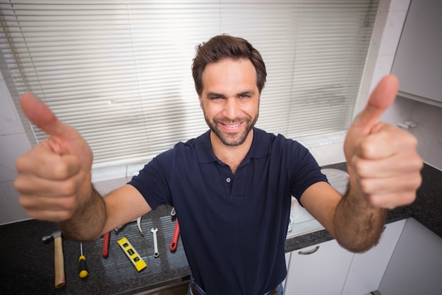 Foto loodgieter die bij de camera glimlacht