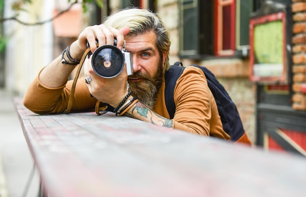 Посмотри на меня. мужчина фотограф делает съемку. съемочный день хобби. хобби и досуг. зрелый опытный оператор. папарацци используют цифровую камеру. сеанс фотосессии. стрельба с рук.