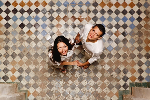 Look from above at lovely couple standing on the backyard of an old Morrocan house 