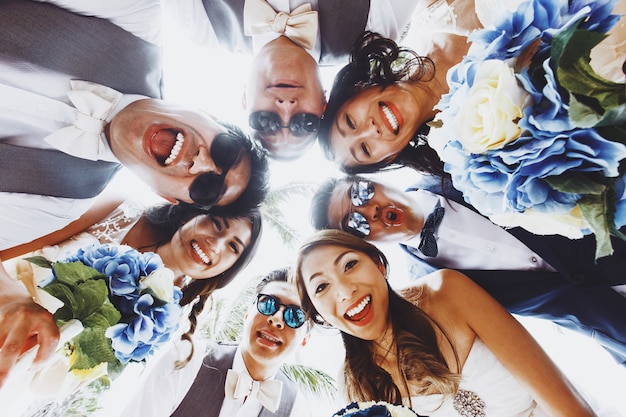 Look from below at newlyweds and friends hugging outside