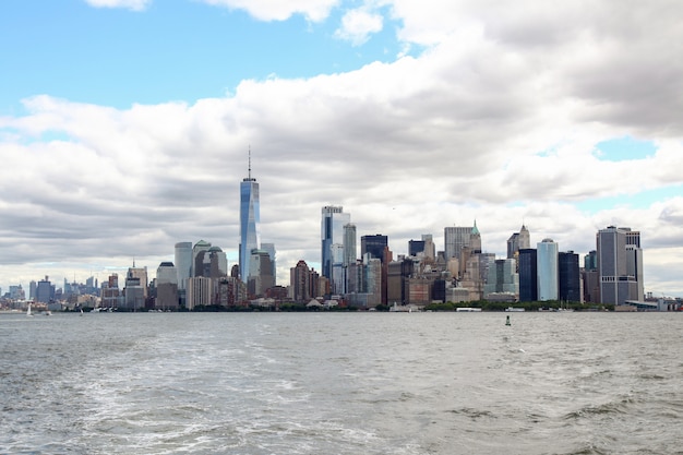 Look on the sailboat is cruising in New York harbor buildings of Manhattan island 