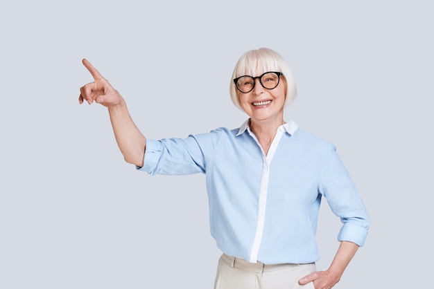 look over there! beautiful senior woman pointing copy space and smiling 