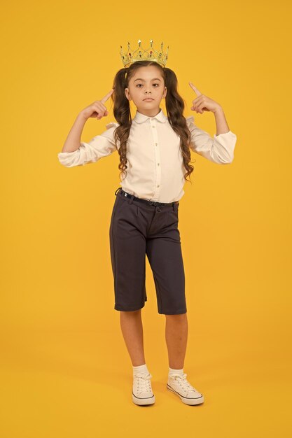 Look who is a big boss here Little big boss on yellow background Cute girl boss wearing crown Small child with big ambitions Adorable boss lady being serious for dreaming big