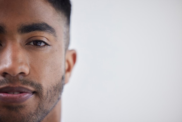 Look the world straight in the face Portrait of a young businessman standing against a grey background