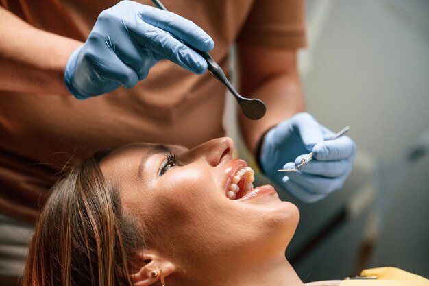 Foto guardando l'allineatore controllando la condizione donna nella clinica di stomatologia in visita dal dentista