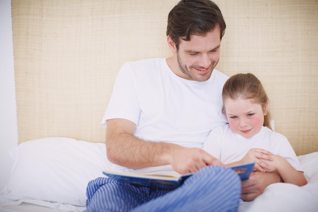 Looking at all the pictures Shot of a devoted father reading his young daughter a bedtime story