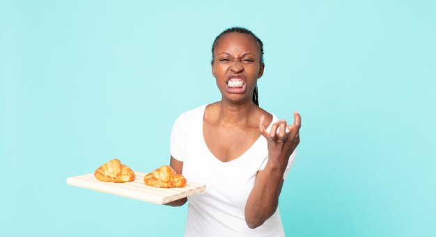 Looking angry, annoyed and frustrated and holding a croissant tray