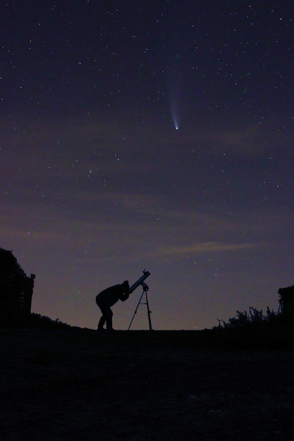 사진 밤 하늘 에 비추어 망원경 을 통해 혜성 을 바라보는 것