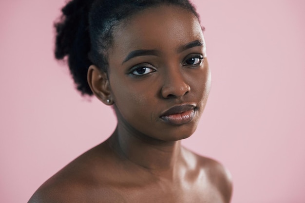 looking in the camera portrait of young african american woman that is against pink background