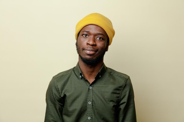 Looking at camera young african american male in hat wearing green shirt isoloated on white background