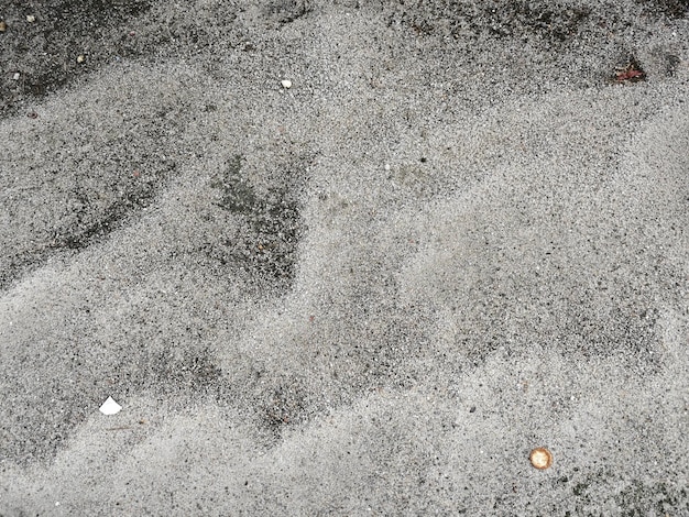 looking down on the surface of the asphalt road with sandy soil texture