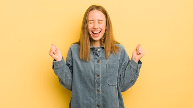 Looking extremely happy and surprised celebrating success shouting and jumping