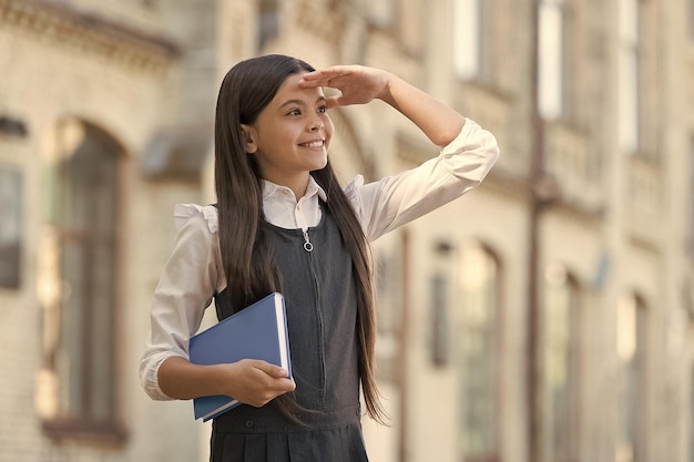 将来を楽しみに本を持って幸せな子供を先取り未来のコンセプト学校は子供時代の教育を待っています大きな夢を見る意欲を持って未来は明日ですあなたの夢を達成するために一生懸命勉強してください