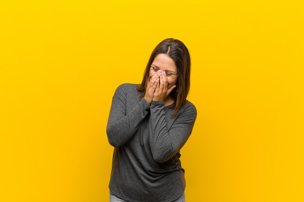 Looking happy, cheerful, lucky and surprised covering mouth with both hands