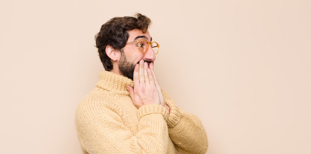 looking happy, cheerful, lucky and surprised covering mouth with both hands