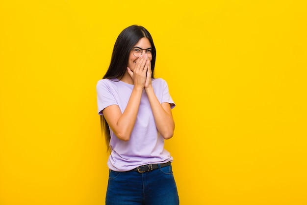 looking happy, cheerful, lucky and surprised covering mouth with both hands