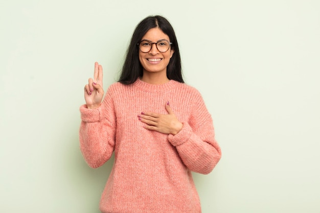 Looking happy confident and trustworthy smiling and showing victory sign with a positive attitude