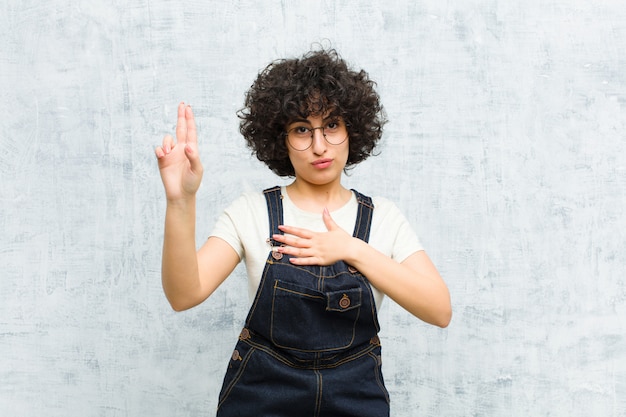 looking happy, confident and trustworthy, smiling and showing victory sign, with a positive attitude