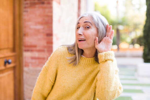 Looking happy listening trying to hear a secret conversation or gossip eavesdropping