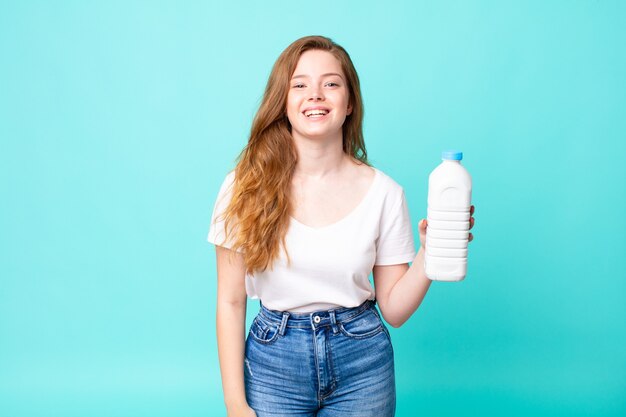 Looking happy and pleasantly surprised and holding a milk bottle