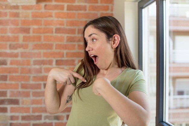 Foto sembrando felice orgoglioso e sorpreso allegramente indicando se stessi sentendosi fiducioso e nobile