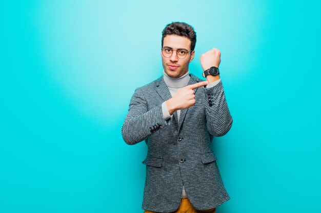 looking impatient and angry, pointing at watch, asking for punctuality, wants to be on time