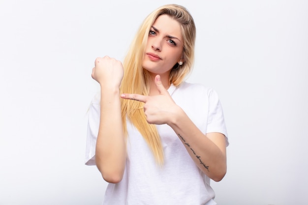 looking impatient and angry, pointing at watch, asking for punctuality, wants to be on time